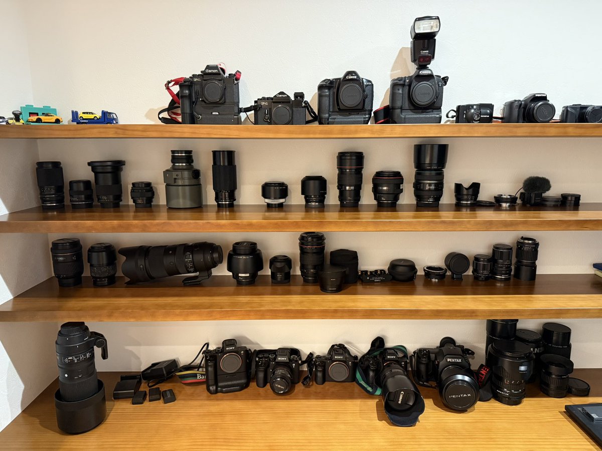 FDLens's tweet image. 引っ越しに伴いできたカメラ収納スペース。作業場が壮観な眺めになり、お客さんが来てもミュージアム感出るようになった。キヤノン率高めだけど…