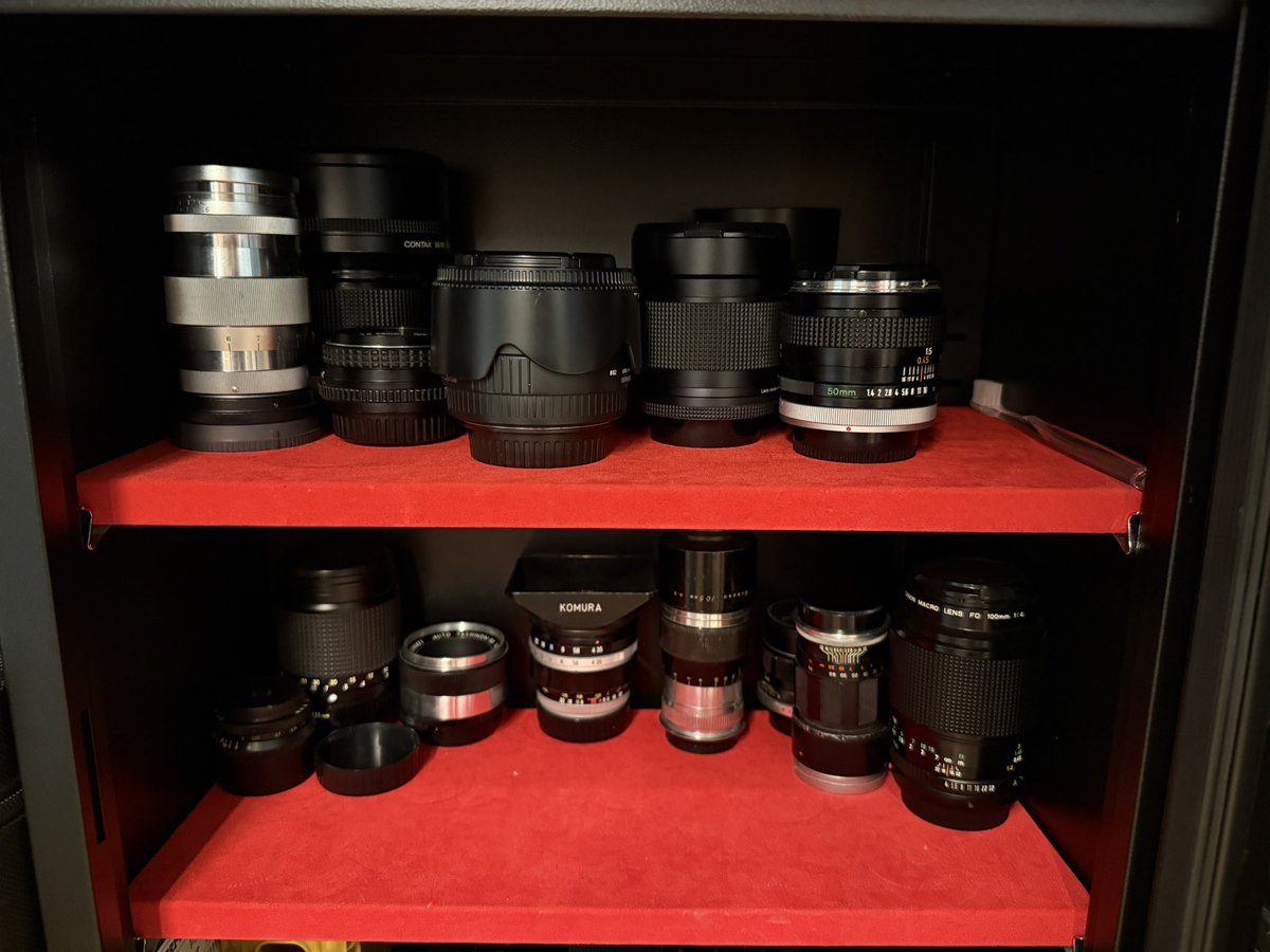 FDLens's tweet image. 引っ越しに伴いできたカメラ収納スペース。作業場が壮観な眺めになり、お客さんが来てもミュージアム感出るようになった。キヤノン率高めだけど…