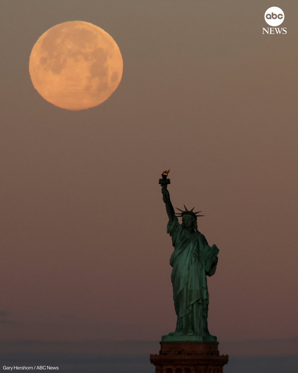 ABC's tweet image. The full Wolf Moon supermoon sets behind the Statue of Liberty as the sun rises on Saturday, in New York City. abcnews.link/6uhooY2
