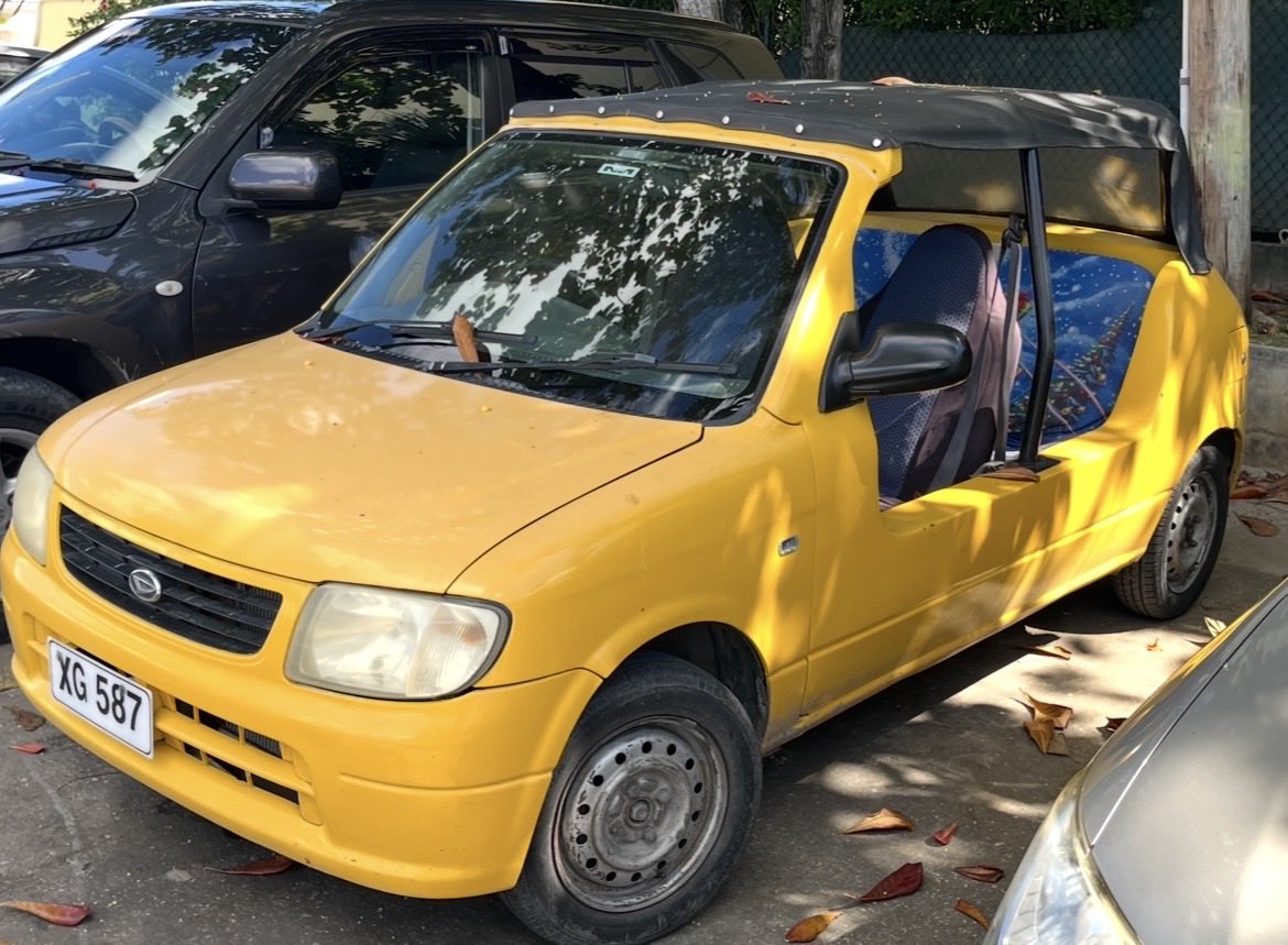 troydmccann's tweet photo. #carspotter Barbados edition.  Roads are narrow, driving is on the left, cars are tiny.  Goodies include Suzuki Ciaz and Swift, this Daihatsu mini moke, a butter-yellow Mitsu pickup, Toyota taxi vans in 3 sizes and a Corolla Axio with a rear wiper. Jimnys, but rental only.  #RHD https://t.co/59fOOKqKBz