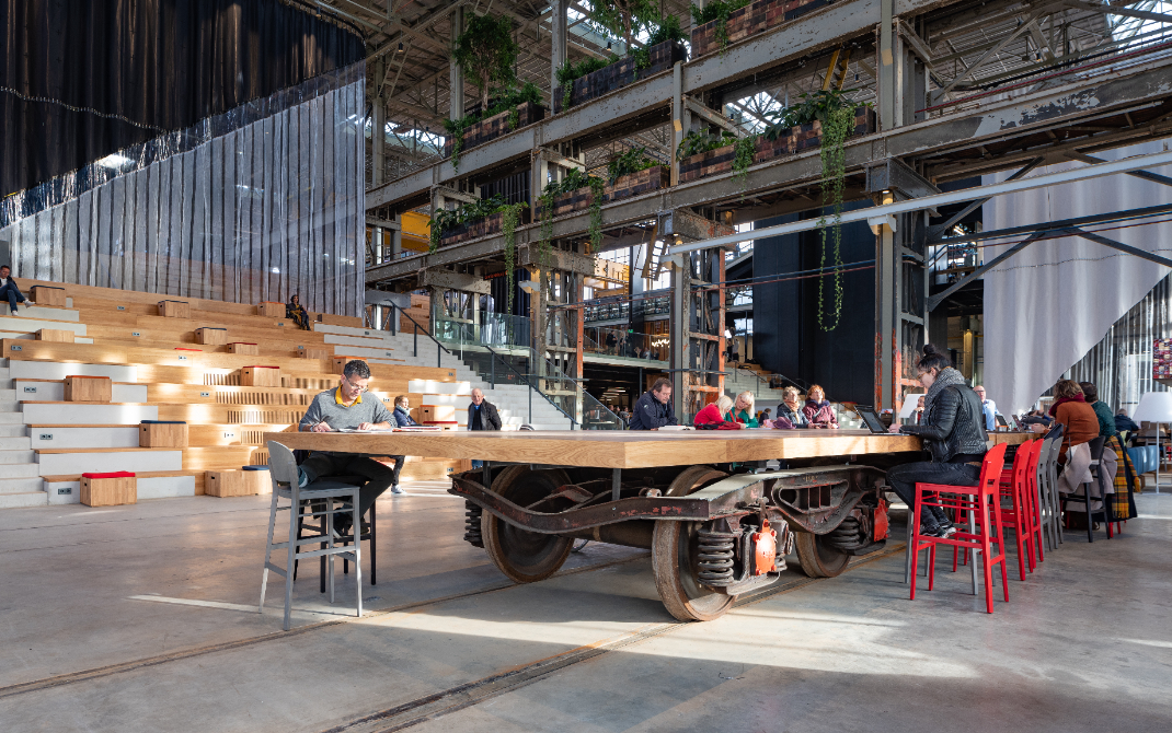 Fun LocHal Fact: 

Wist je dat deze grote tafels in de LocHal op een oud onderstel van een trein staan? Als je goed kijkt kun je ook het oude spoor nog op de grond zien. De tafels kunnen zo makkelijk verplaatst worden en bijvoorbeeld als podium gebruikt worden.