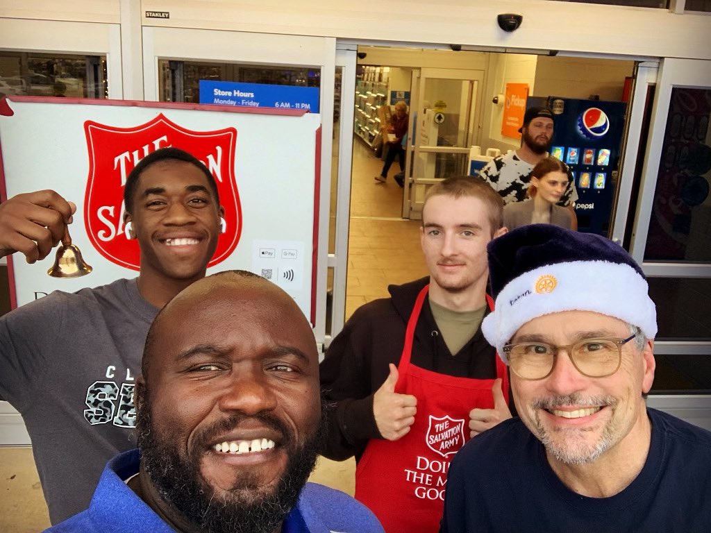 Interact club members ringing the bell with Mr. Neloms &amp; King Laurence.