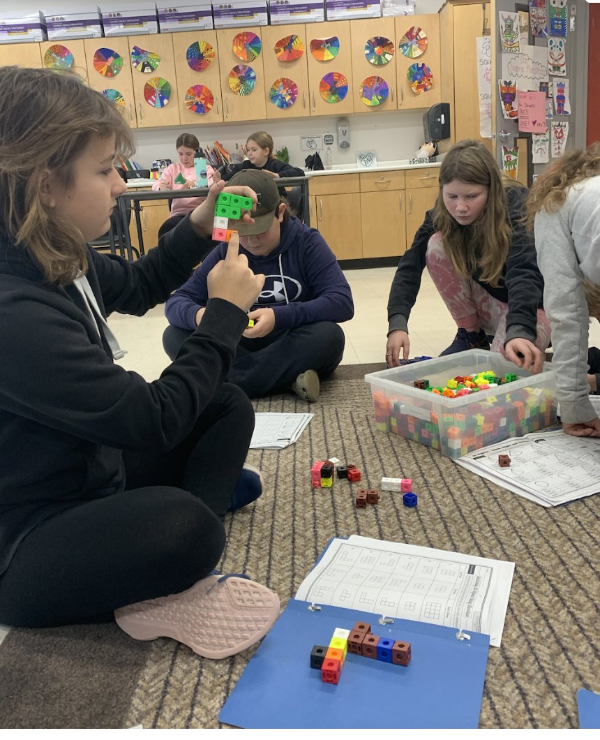 We are learning how to construct 3D objects when given their top, front, and side views.