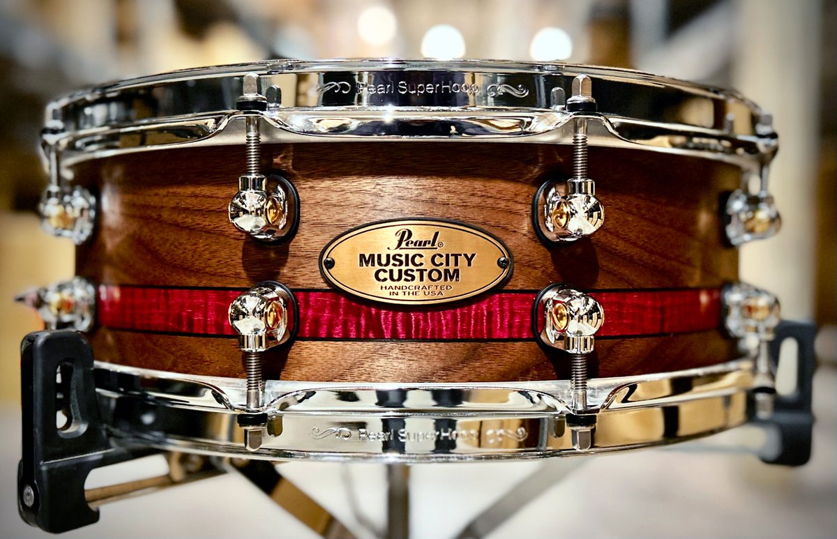 14x5 Walnut Solid Shell with an inlay of Curly Maple between two Macassar Ebony inlays.

8mm solid shell with 6mm solid maple reinforcement rings, STL150 single swivel lugs, 2.3mm Triple-Flanged SuperHoop II.

Music City Custom Solid Shell Craftsman Select Snare Drums are