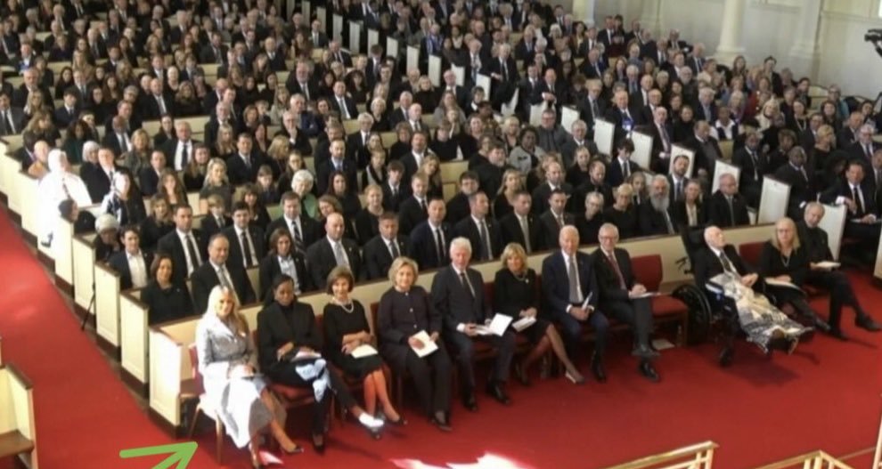 Why is Melania Trump seated at the end of the row, while the Bidens are in the middle? 

That's not the seating arraignment for these kind of events. 

The President sits on the end of the row.  

That should be Joe and Jill Biden sitting where Melania and Michelle Obama are