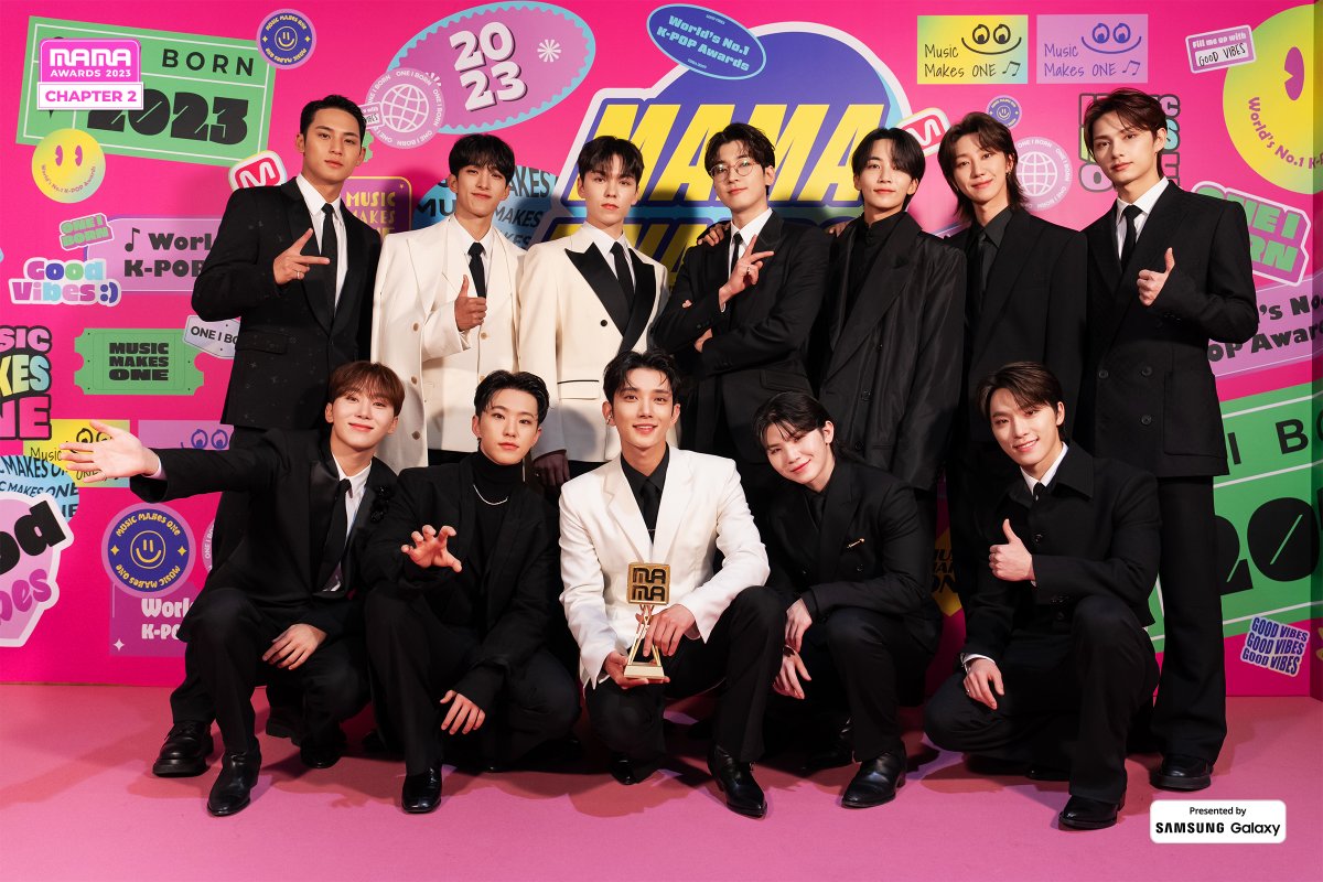 daino's tweet image. capturing a moment of triumph at the 2023 MAMA, we struck poses in a delightful pink-themed photo spot, adorned with charming designs. holding our first trophy, the joyous ambiance merged with the whimsical backdrop, creating an enchanting visual tableau.