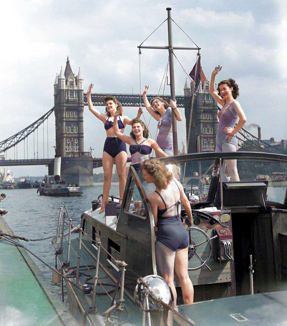 englandincolour's tweet image. Dancers from the Windmill Theatre dock alongside the Thames Beach by Tower Bridge, c1946.  #windmilltheatre #riverthames #towerbridge #theforties #the40s #swimwear