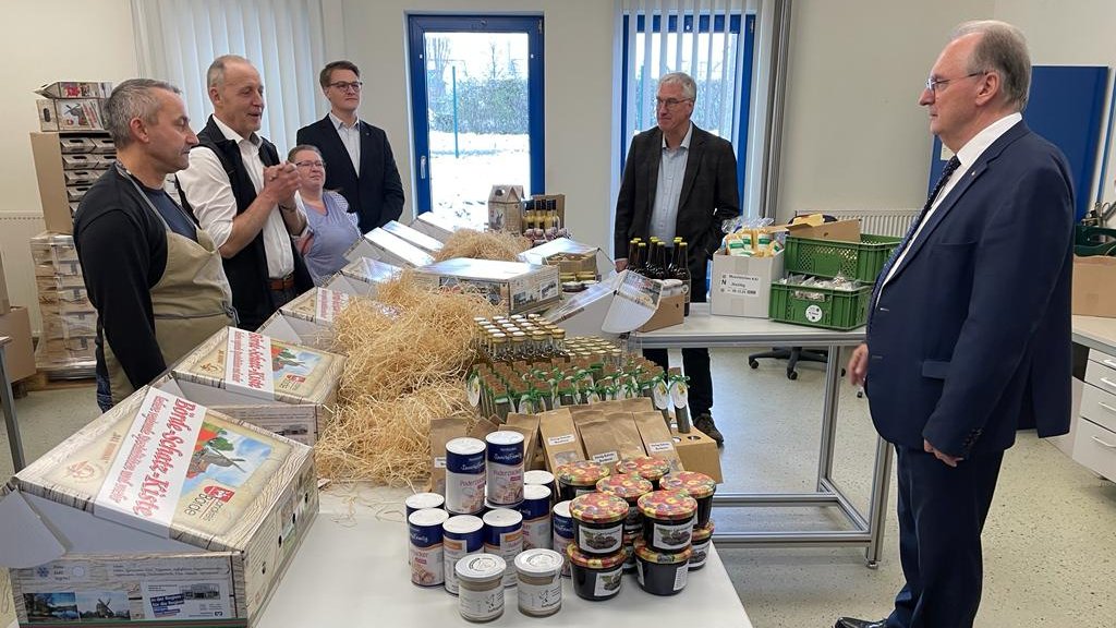 sachsenanhalt's tweet photo. 10 Jahre #Börde|schatzkiste. MP @reinerhaseloff besucht die #Lebenshilfe Ostfalen in Seehausen/Börde und unterstützt beim Packen der „AMG-Bördeschatzkiste“. "Liebe geht bekanntlich durch den Magen. Auch die Liebe zur Region macht da keine Ausnahme", so der MP. #SachsenAnhalt https://t.co/K5hmGEvEwp