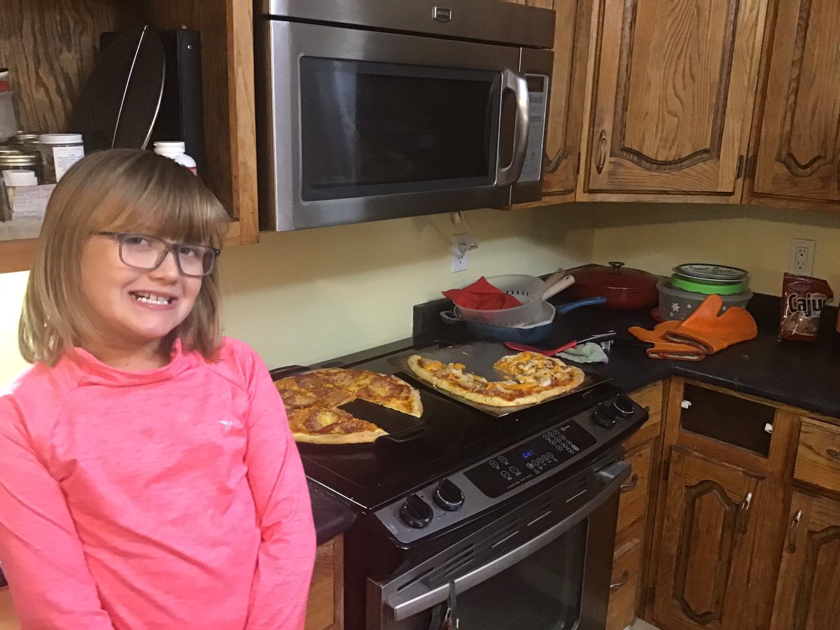 Standing on a stool to show off the pizza she made herself (ok Grandpa made it round but only right at the end). Why 2 for 2 people? Because hers are boring and she won’t do onions, peppers, and anchovies.