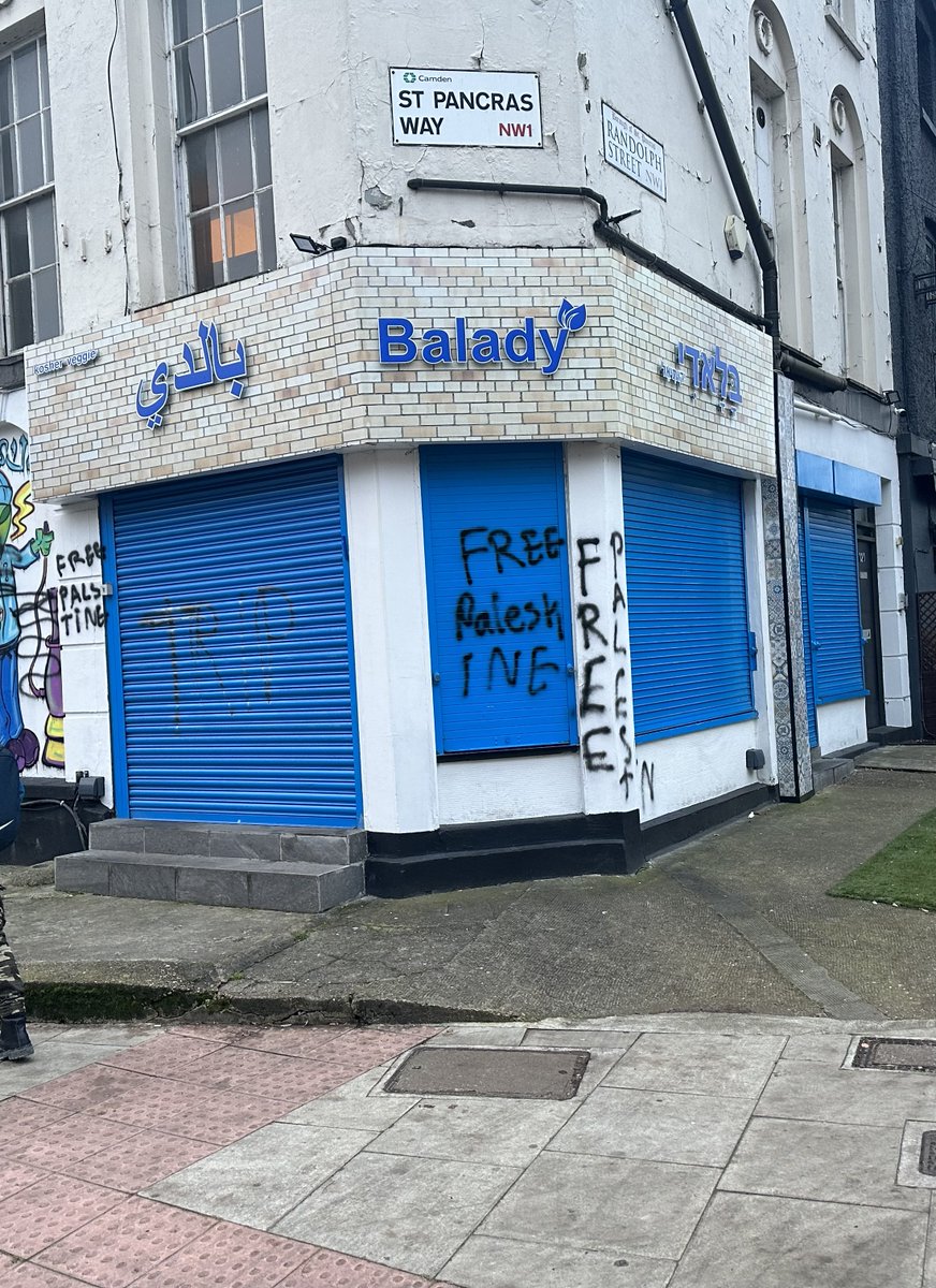 AdamWagner1's tweet photo. Every time I cycle into work I pass the Camden branch of Balady, one of the best kosher falafel restaurants in London, I always smile at the Hebrew, Arabic and English writing on the sign, and get a little hungry because the food is delicious.

This morning I saw this clearly racially aggravated graffiti.

The owners, who are lovely in my experience, may well be feeling intimidated by this. Can I ask that people who read this consider ordering a delivery or going into one of their branches (Temple Fortune, High Barnet, Camden or Leather Lane) or ordering a takeaway? I guarantee you won't regret it as the food is wonderful.

https://t.co/twtQKmezqm