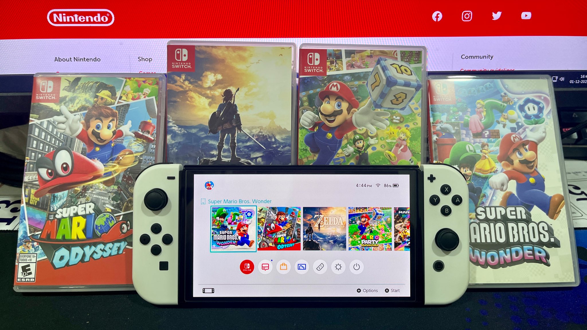 Nintendo Switch OLED console surrounded by copies of Super Mario Odyssey, Super Mario Wonder, Super Mario Party and The Legend of Zelda: Breath of the Wild