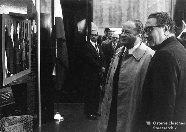 Vor zwei Tagen starb Henry Kissinger. Dieses Foto zeigt ihn mit dem damaligen österreichischen Bundeskanzler Bruno Kreisky. Die beiden hochrangigen Politiker blicken auf ein Foto aus dem Jahr 1974, auf dem Kreisky von Gerald Ford im Weißen Haus empfangen wird. Quelle: BPD/ÖStA
