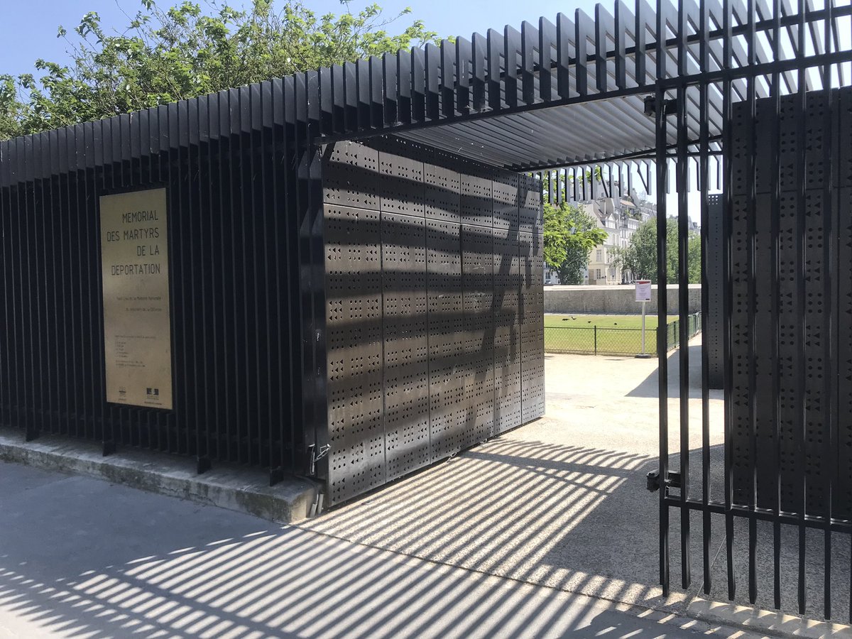 👉 Le langage -architectural, végétal et symbolique- des cimetières est présent dans le square du Mémorial des Martyrs de la Déportation :
- la grille pour délimiter et protéger l’espace
- l’entrée couverte qui invite au recueillement 1/3