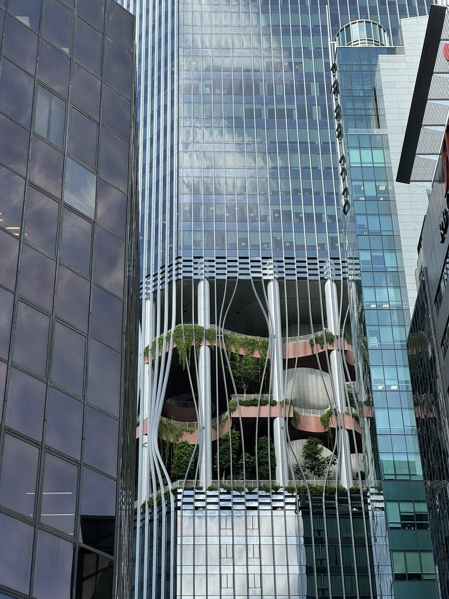 BIGとCRAが手がけたCapitaSpringは、業務/住宅ビル。4層の無料公共スペースがあり、連続する垂直材の歪み部分から自然が覗く。シンガポール最高の超高層ビルで、バイオフィリックなデザインが高密度都市に自然をもたらす。
