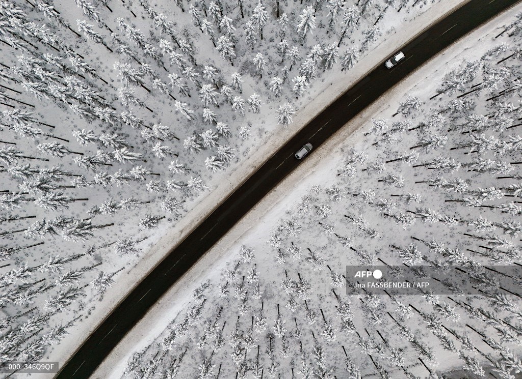 #Germany An aerial view shows cars on a road crossing the snow-covered landscape at the Kahler Asten mountain near Winterberg. 📷@inafassb #AFP