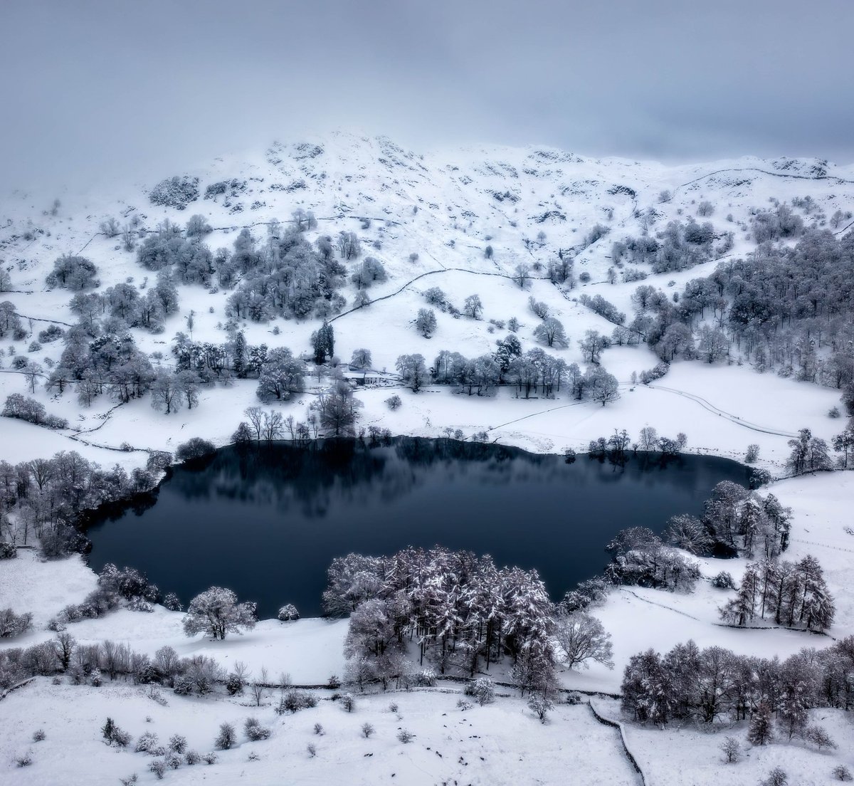 Morning everyone hope you are well. Not a black and white shot! Views across Loughrigg Tarn towards Loughrigg Fell. Paths around Ambleside are lethal this morning (I wear ice grips), so take care. Have a great day. #LakeDistrict <a href="/keswickbootco/">Keswick boot co</a>