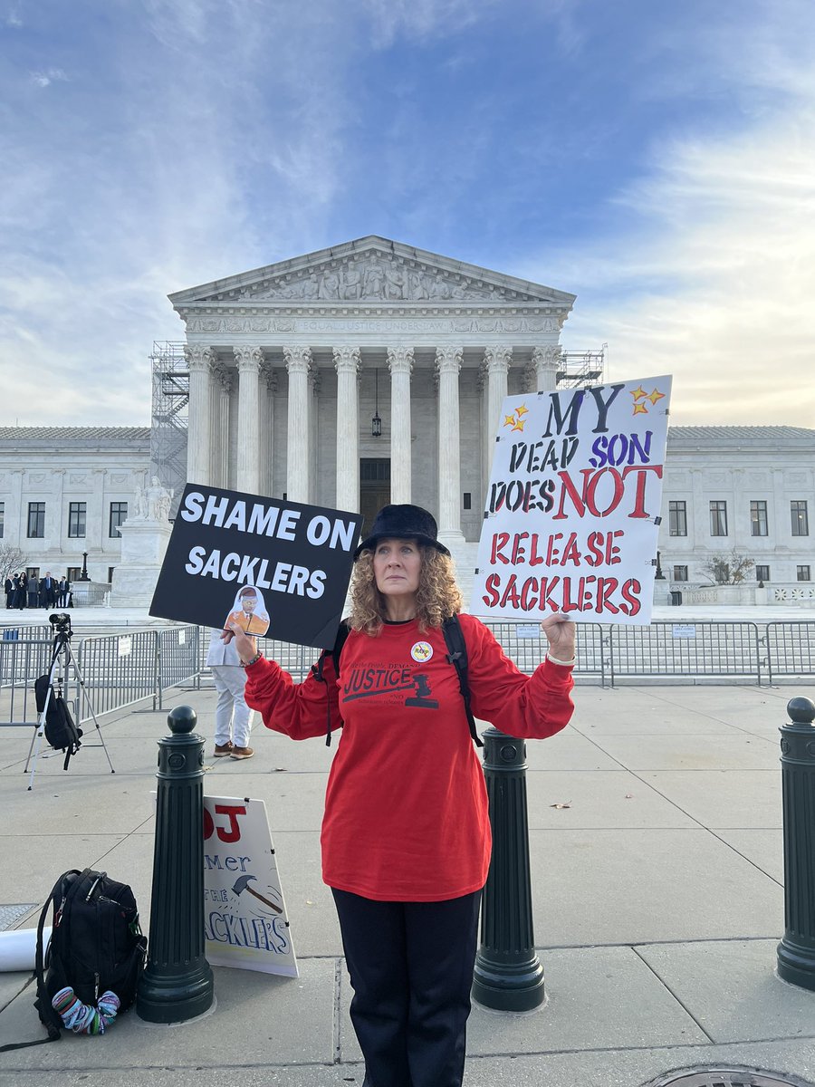TaylorHarrison5's tweet photo. Grace Bisch, holding up signs for the protest ahead of Purdue Pharma’s Supreme Court arguments today, which start at 10am. https://t.co/BXXqbbdtkh