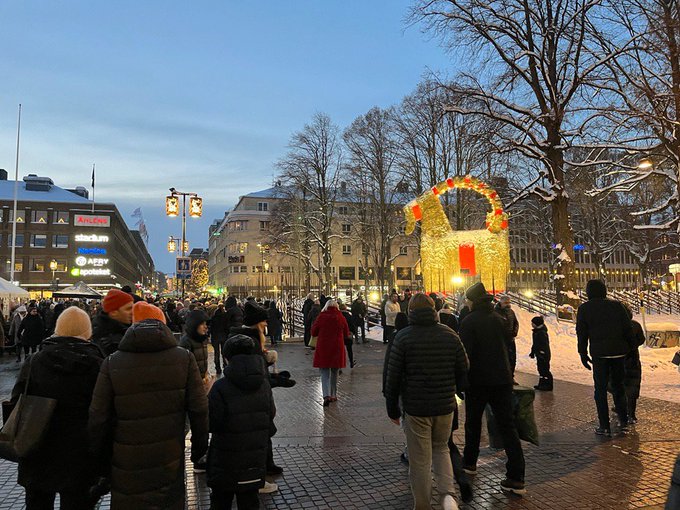 A picture of a crowd of people in front of Gävlebocken, the worlds largest straw goat.