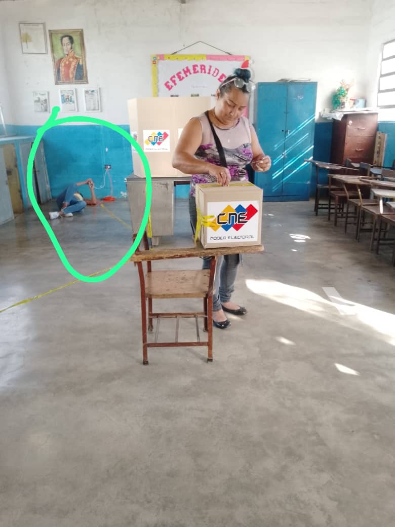 Observen bien a la chica (TESTIGO de MESA) en el suelo, con su teléfono conectado a la máquina de votación y la votante (Jefa de la UBCH del barrio) con más de una papeleta en las manos introduciéndolas en la urna. Què dirà la Observaciòn Internacional ??