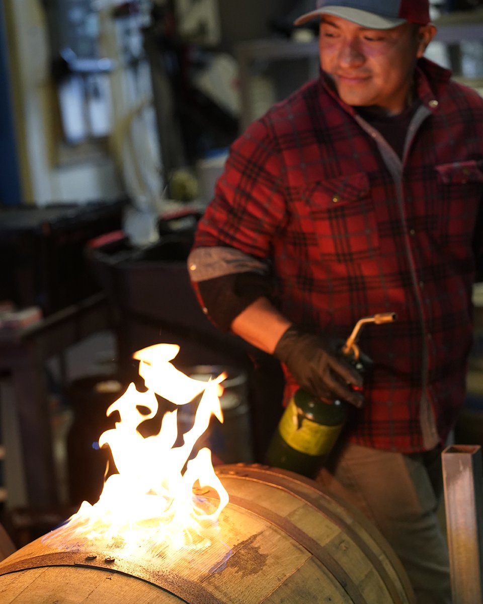 Here's a behind-the-scenes look at barrel aging!  When it's time to empty the barrels, we have to sterilize the opening with fire.  This kills any microorganisms in the area, plus it looks really cool! #craftbeer #barrelaging #barrelagedbeer