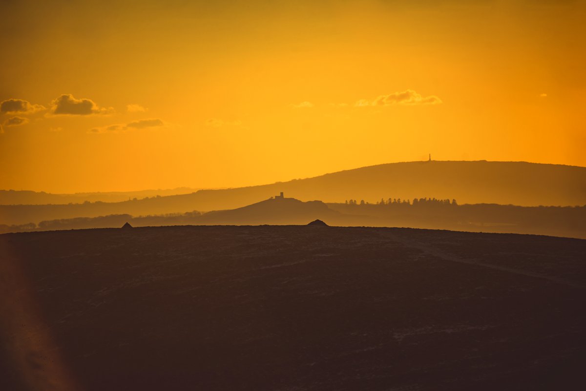 GlavindStrachan's tweet photo. The cairns on top of #GreatNodden, St Michael de Rupe Church at #Brentor and the mine chimney on #KitHill all in one photograph, taken with an old #Tokina 400mm lens 📷 as the sun went down on Friday 💚 #DartmoorPhotographer #EnglishLandscapes #BritishLandscapes #Dartmoor https://t.co/lA6hj8rCtj
