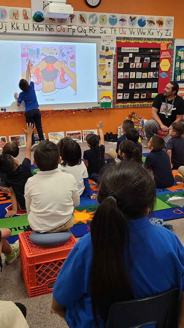 DanielVandever's tweet image. A Native guy with long hair reading his book about Native hair while a Native boy with long hair listens. Picture books are powerful. #NativeKidLit #Herizon