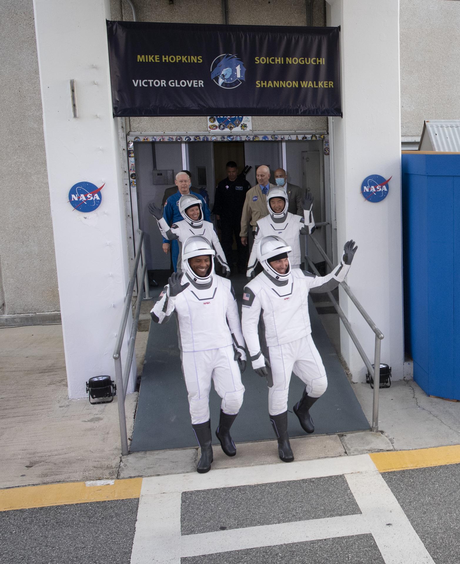 NASA astronauts Victor Glover, front left, Mike Hopkins, front right, Shannon Walker, back left, and Japan Aerospace Exploration Agency (JAXA) astronaut Soichi Noguchi, back right, wearing SpaceX spacesuits, walkout of the Neil A. Armstrong Operations and Checkout Building to depart for Launch Complex 39A to board the SpaceX Crew Dragon spacecraft for the Crew-1 mission launch in Florida.
