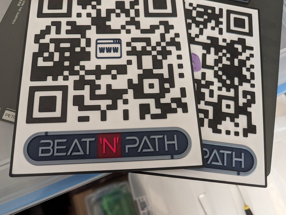 MikeBBerger's tweet photo. I'm so happy with how this #3dprint turned out. I wanted to do something a little cooler than paper QR codes, so I took some QR codes and our #indiegame logo in SVG, and modelled these in F360. I also embedded an NFC tag in them with the URLs.  Printed on my @BambulabGlobal #x1c https://t.co/5nJlwn4jO5