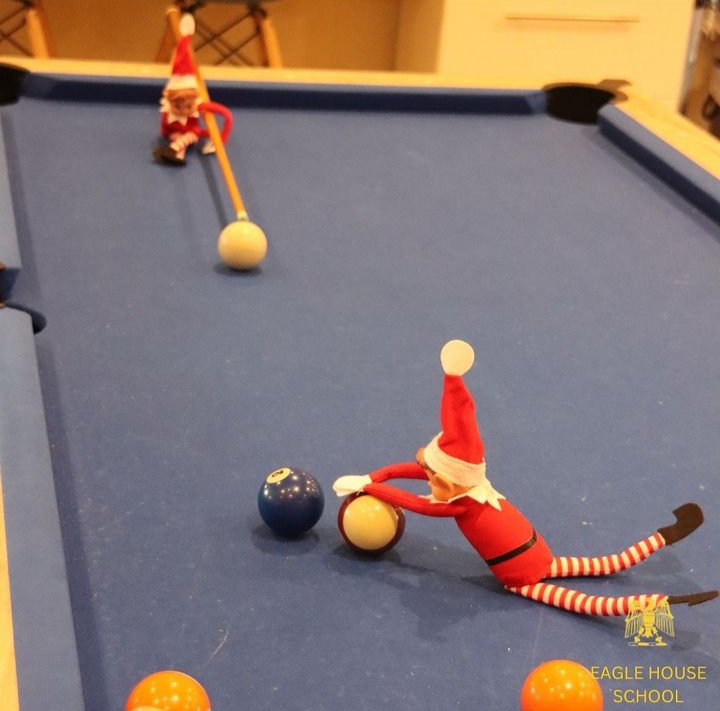 Day 7: The elves have snuck out of lessons to play pool in the boarders' common room. Who is going to win, Agnes or Ian? #eaglehouseschool #berkshireprep #prepschool #festives #ElfOnTheShelf #AI