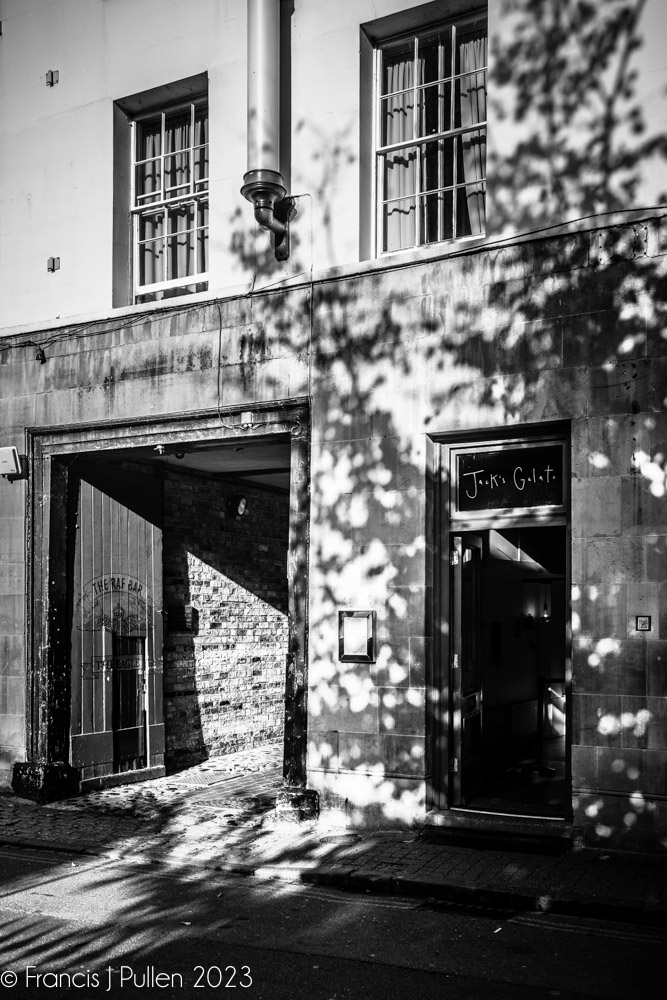 Light and Shadows Series
Early morning late autumn sunshine falls across the coach entrance to  The Eagle Pub Bar with a Richardson Candle street light above, and  frame Jack's Gelato in rich deep shadow in  Bene't Street central Cambridge.
#chiaroscuro #eaglepub #jacksgelato