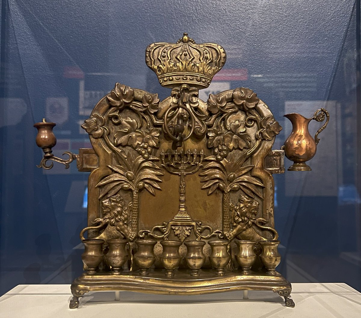 Happy Hanukkah!🕎 This hanukkiah was made in Poland c. 1900 & used by the Sol & Bertha Leaf family. Its style, which represents the biblical Garden of Eden, was popular at this time & features palm trees, grape leaves, & animals. Learn more in #BackHomeCHM ow.ly/5WlT50Qgsa8