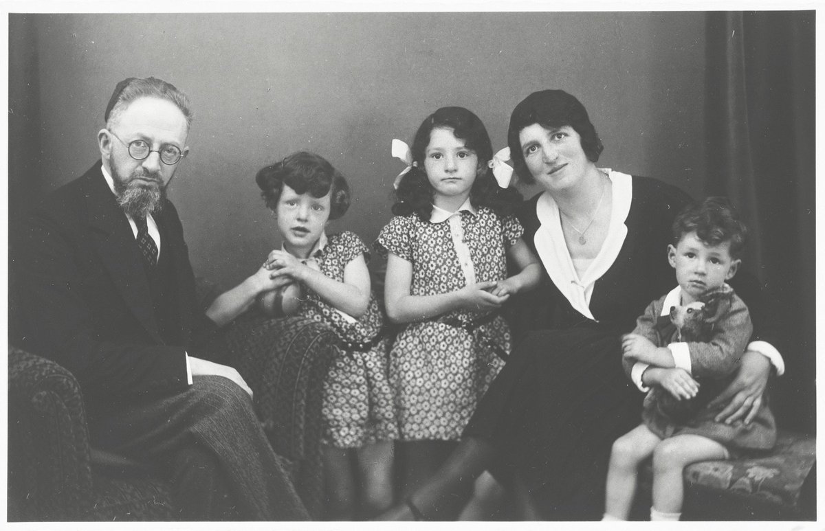 During Hanukkah in 1931, Rabbi Akiva Posner’s family placed a menorah in the window—an outward sign of their faith. Through the panes, a swastika flag is seen on a Nazi Party office. The family fled Nazi Germany in 1933 with the candleholder. Their descendants still light it.