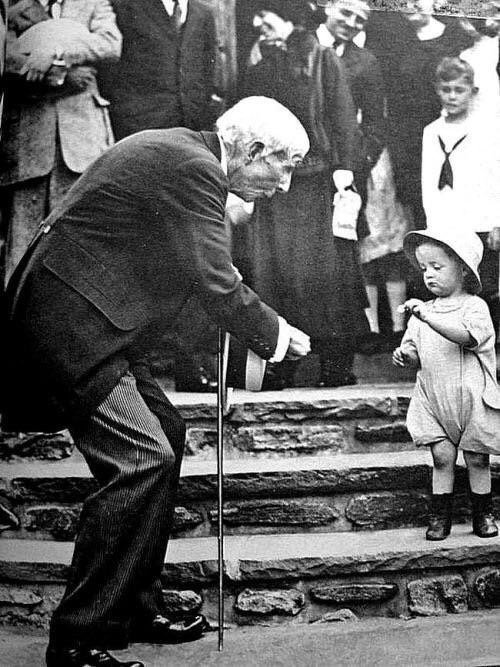 John D. Rockefeller gifting a 5 cent coin to a child on his 84th birthday, 1929.