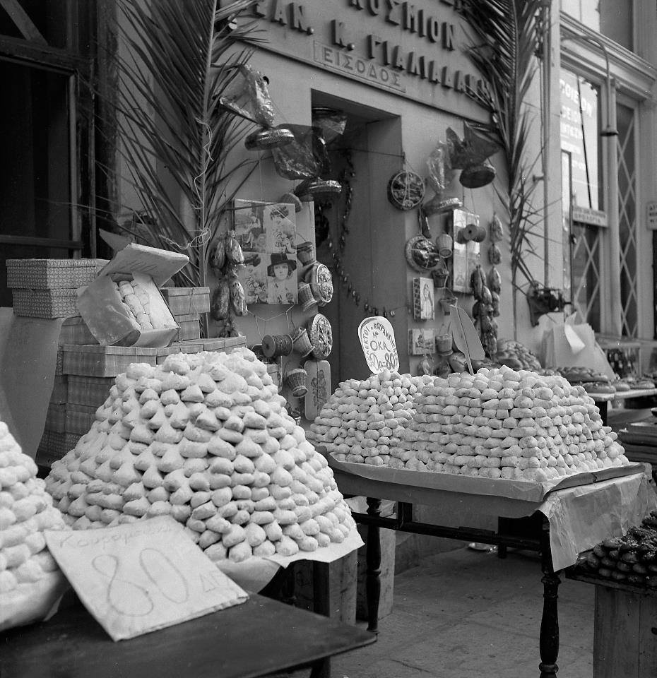 🎄In Greece you know Christmas has arrived when the air carries the heart-warming scent of freshly baked #kourabiedes & #melomakarona -traditional Christmas cookies- through the streets 📷Voula Papaioannou. Christmas sweets, Athens 1950s © @TheBenakiMuseum Photographic Archives