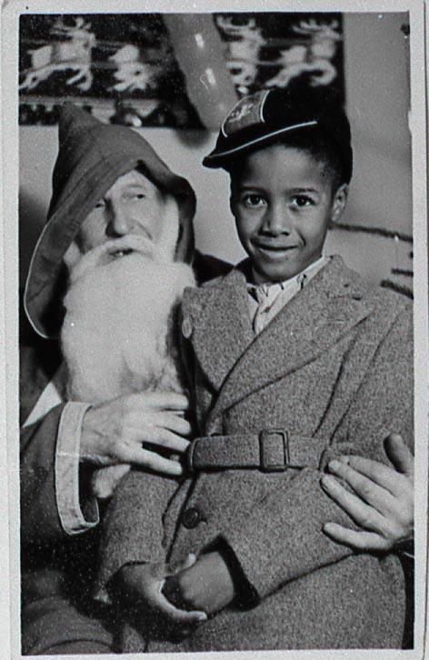 Who has childhood memories of meeting Santa Claus? 🎅✨ This lovely photograph captures the moment when Philip Brown met Father Christmas at the Dan Evans store in Barry. 🔗bit.ly/VisitingFather… 📷 Barry Library / @VOGLibraries