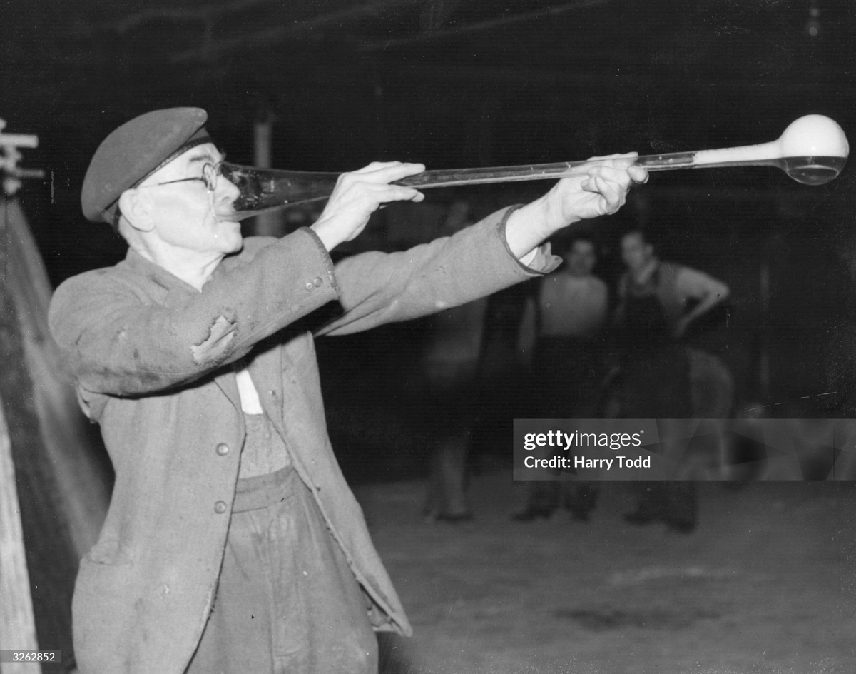 78-year-old Ben Smart enjoys a yard of ale in an old custom to celebrate Christmas at the Whitefriars Glassworks, Wealdstone, Middlesex, where he has worked for over 30 years (1954)