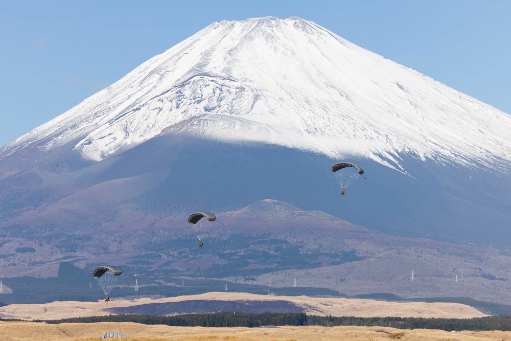 U.S. Marines descend after jumping from a U.S. Army UH60 Blackhawk during Military Free Fall operations over CATC Camp Fuji, Japan. The training sustains operational readiness while ensuring Marines are prepared to rapidly insert into austere environments through multiple methods