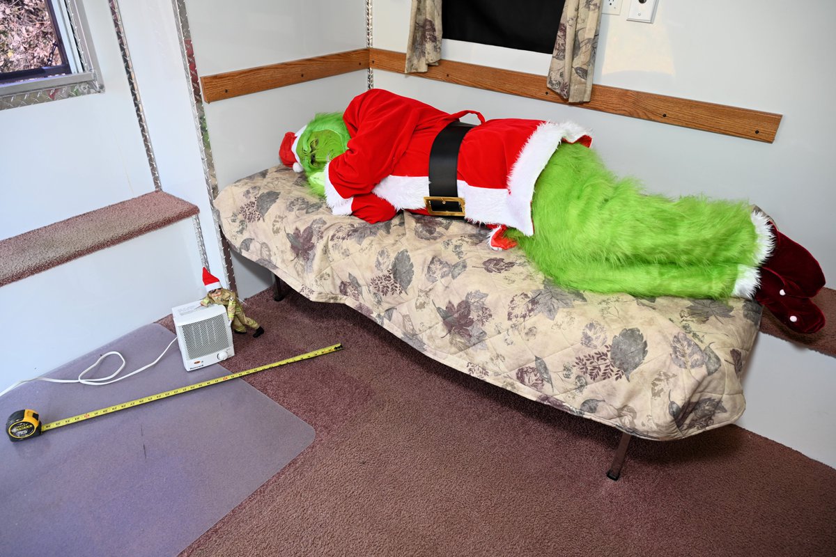 #FernoTheElf is on duty with his trusty tape measure, ensuring our snoozing green friend keeps a 3-foot distance from the space heater. Loose sheets and heating equipment? Not on Ferno's watch! #SafeHeating #ThreeFeet