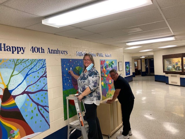 Our Happy 40th Anniversary sign goes up over our beautiful new school murals!