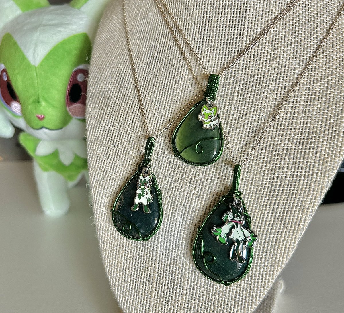 thefabledfoxart's tweet photo. Introducing the Sprigatito evolutionary line in pendant form! Each piece features an authentic Pokemon Center charm imported from Japan 💚

Sprigatito: Serpentine
Floragato: Moss Agate
Meowscarada: Bloodstone https://t.co/hcqgDTA1no