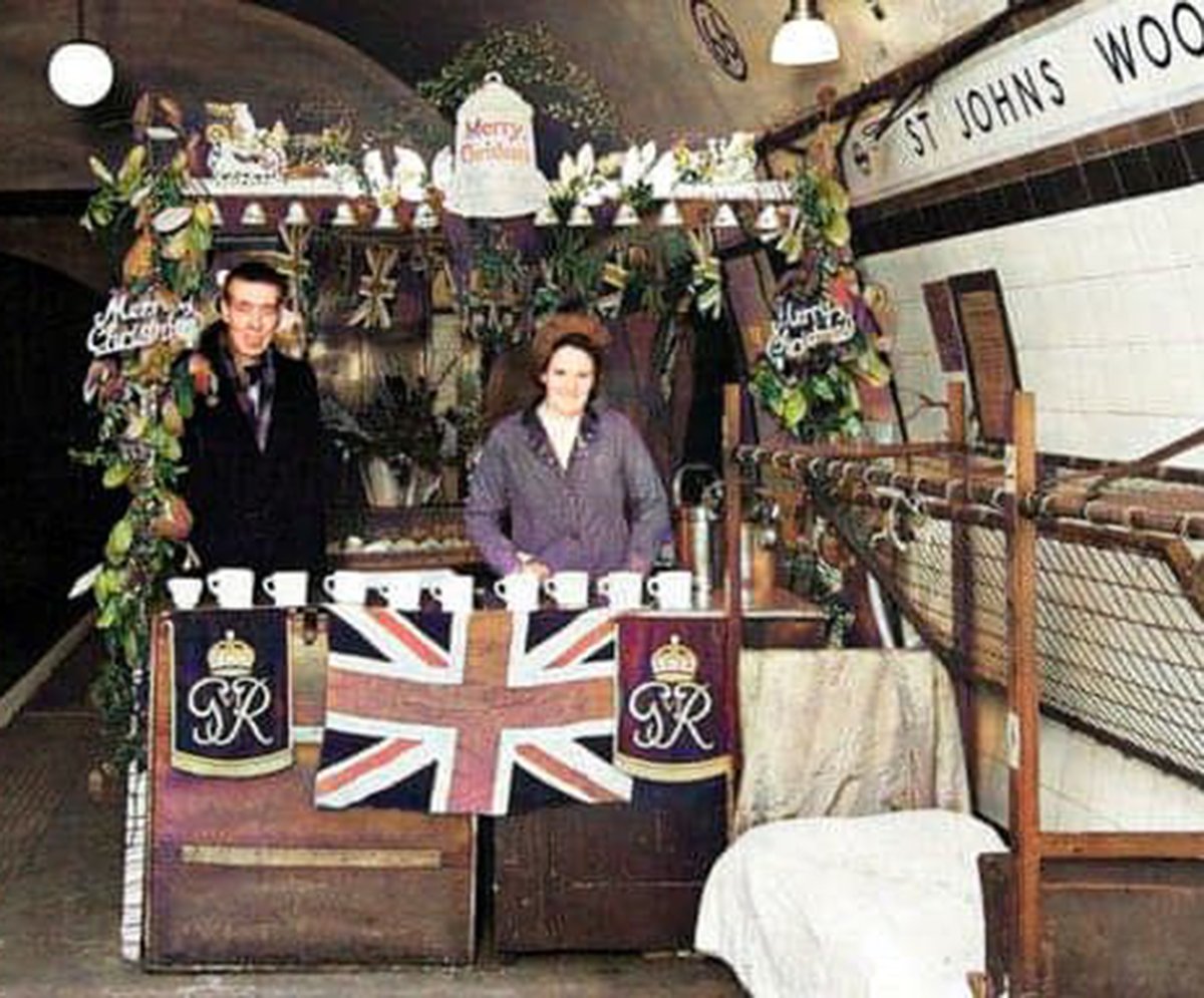 A festively-decorated refreshments stall on the platform at St Johns Wood Underground station for those using it as an air-raid shelter at Christmas in 1944. Photo London Transport Museum Collection. #stjohnswoodstation #ww2 #wwII #londonunderground #christmas #airraidshelter