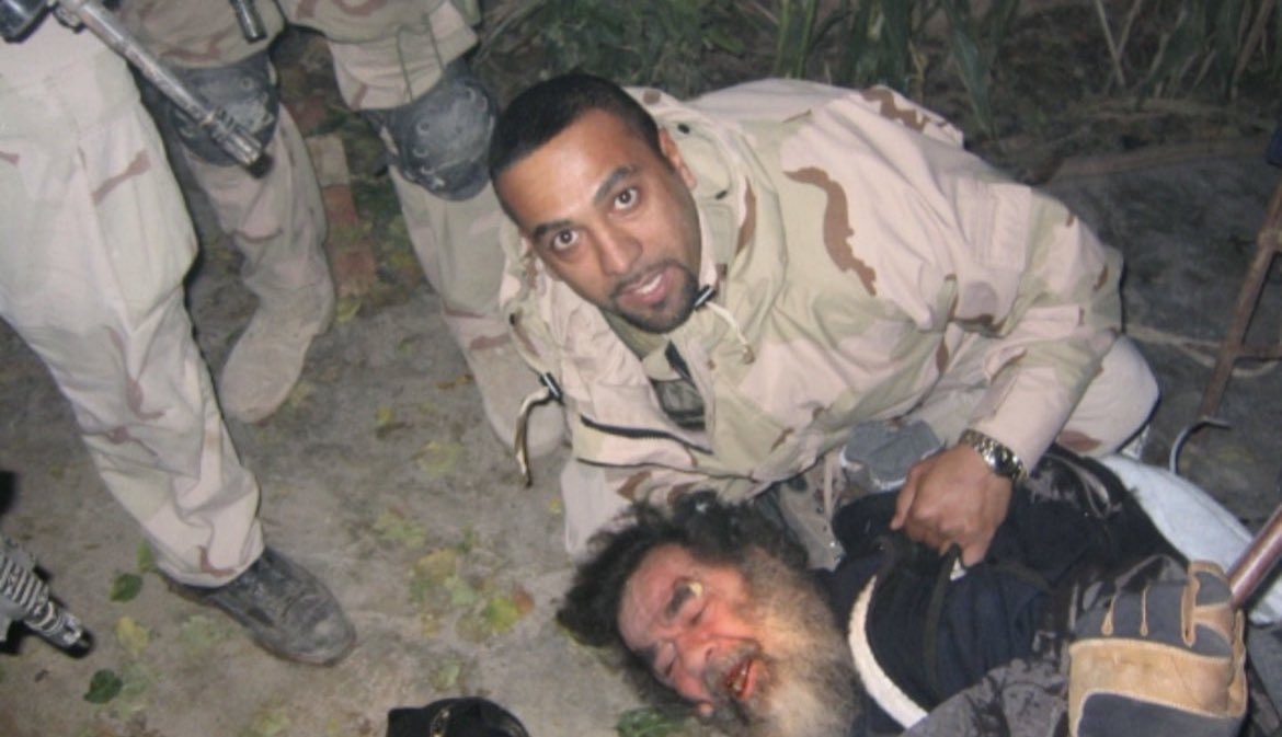 Photo from December 13th, 2003, shows Iraqi-American soldier Samir pinning Iraqi leader Saddam Hussein to the ground.