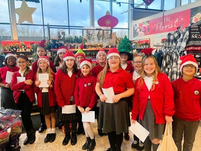 The well-being choir from Coten End Primary School singing at a local supermarket
