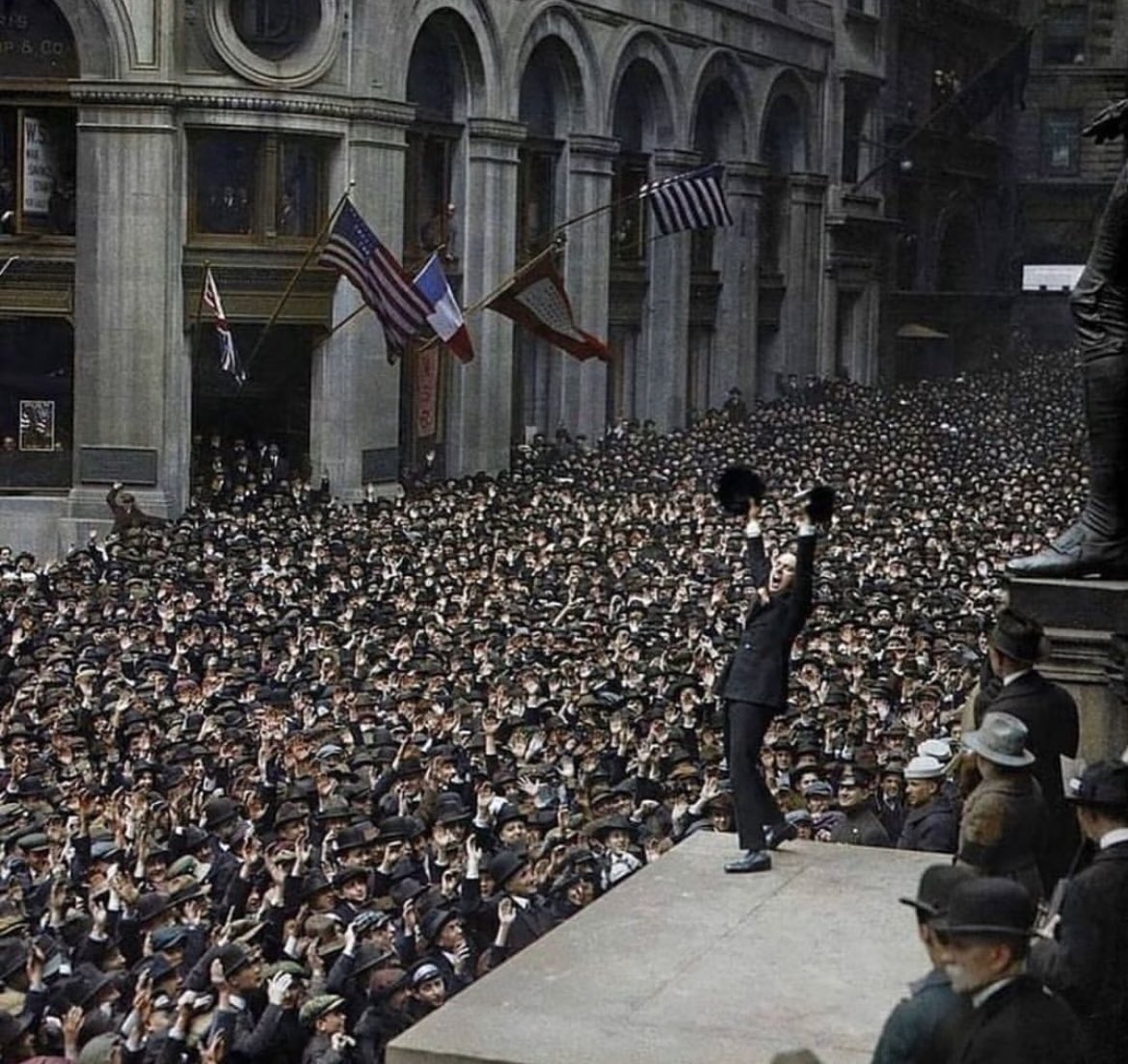 This famous photo from April 9, 1918, captures actor Charlie Chaplin being lifted by fellow actor Douglas Fairbanks during a Wall Street rally to promote the sale of war bonds. The event took place at the base of the United States Sub-Treasury Building, now known as Federal Hall.
