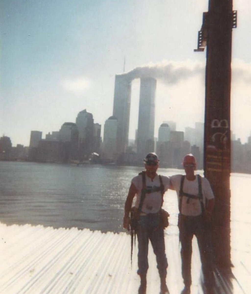 Two builders pose for a photo with the World Trade Center towers on 9/11.