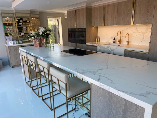 This bespoke kitchen designed and installed by Brandt Design serves a couple who likes to entertain, and features a dedicated home bar with integrated seating 😍 Our #Urban furniture is finished in Grey Wild Oak and paired with Satin Brass accents 🌐 brandtdesign.co.uk/kent