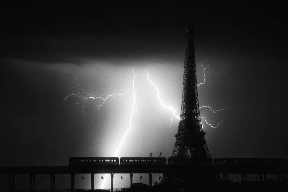 'Foreshadowing' by @DrifterShoots captures a moment of electrifying contrast, where the thrill of urban exploration meets the raw power of nature, the silhouetted Eiffel Tower standing defiant against the dramatic ballet of lightning.