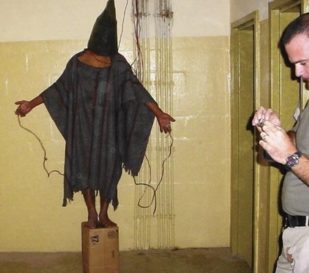 Photo from November 2003 shows a prisoner being subjected to torture at Abu Ghraib Prison by US forces. The prisoner had electric wires attached to him, with the threat of electrocution if he fell off the box.