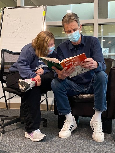 Bryan Marjoram, reading some holiday favourites to the Monday Afternoon Book Club today. Here Maddy is looking on as he reads from 'How the Grinch Stole Christmas' by Dr. Seuss. #BooksConnect