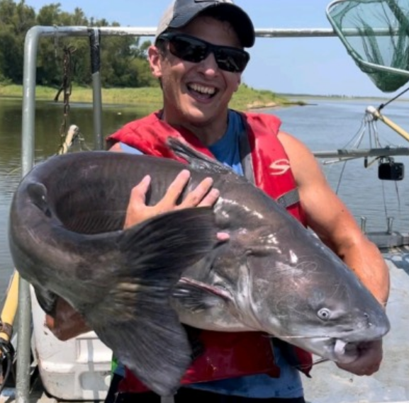 atufws's tweet photo. For the 7th day of Fishmas, this is a Blue Catfish sampled on the Arkansas River for the Least Tern Monitoring Project by Shelby Hunter (Pictured), Coley Turner, and Nathan Mansor. https://t.co/4sN2TbUqWE